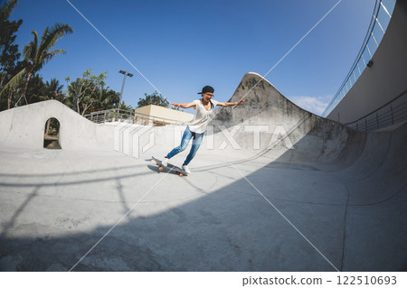Skateboarder skateboarding at skatepark in city Skateboarder skateboarding at skatepark in city 122510693