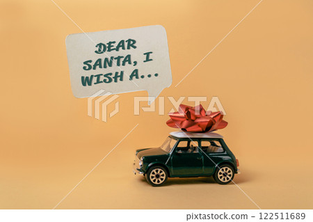 Toy car with a red bow on top of it and a message that says Dear Santa Toy car with a red bow on top of it and a message that says Dear Santa 122511689