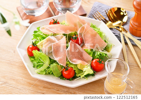 Prosciutto, green salad, frilly lettuce, avocado, radish sprouts, cherry tomatoes. The white flowers are artificial. 122512165