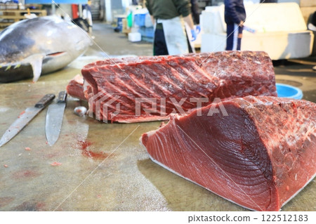 Raw tuna being cut into pieces - Bluefin tuna block 122512183