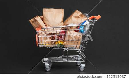 Illustrative depiction of a full shopping cart, free standing in front of a background of the same color, consumption and shopping pleasure - ai generated Illustrative depiction of a full shopping cart, free standing in front of a background of the same color, consumption and shopping pleasure - ai generated 122513087