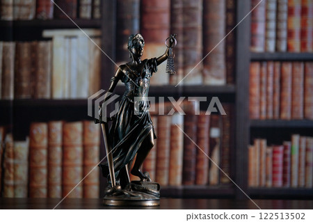 Law and wisdom. Statue of Lady Justice near shelves with books. 122513502