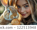 Easter bunny and smiling white girl with painted egg. 122513948