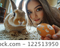 An Easter bunny appears in room of an Asian teenage girl who shows painted egg to camera 122513950