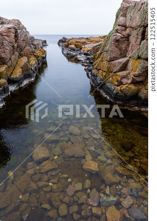 Coast line of sea. Stones covered with yellow and green moss and cloudy sky. Coast line of sea. Stones covered with yellow and green moss and cloudy sky. 122515405