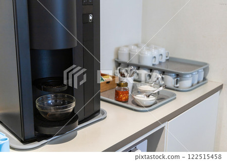 A coffee maker nd clean glasses in the kitchen og a hotel or company. A coffee maker nd clean glasses in the kitchen og a hotel or company. 122515458