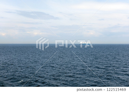 Seascape with a white ferry in the distance and waves. Seascape with a white ferry in the distance and waves. 122515469