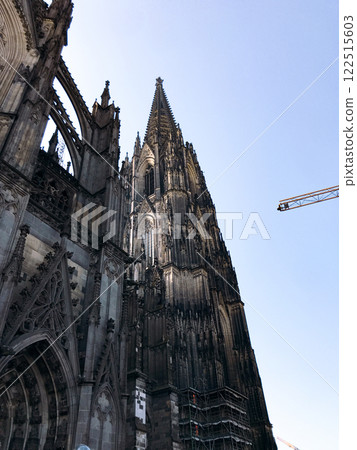 Cathedral in Cologne, Tall building with a pointed roof and a blue sky in the background Cathedral in Cologne, Tall building with a pointed roof and a blue sky in the background 122515603