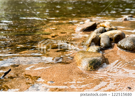 Rocky shoreline with a body of water in the background 122515680