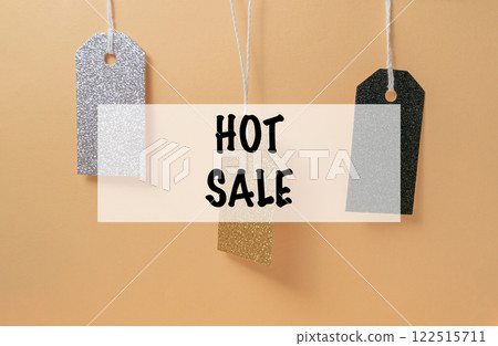 Three tags hanging from a string with the words HOT SALE written below them Three tags hanging from a string with the words HOT SALE written below them 122515711