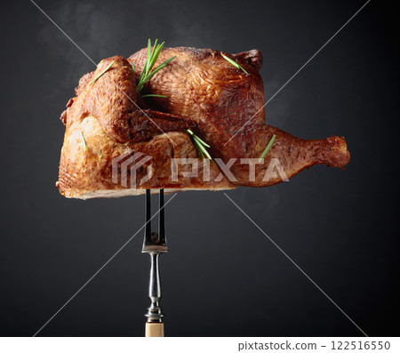 Smoked chicken on a fork sprinkled with rosemary. Smoked chicken on a fork sprinkled with rosemary. 122516550