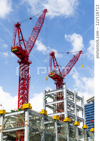 View of cranes and steel structures of building construction with a blue sky background in Taiwan. View of cranes and steel structures of building construction with a blue sky background in Taiwan. 122516713