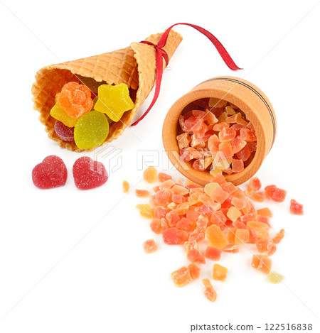 Dried pieces of papaya in a wooden bowl and marmalade in a waffle cone isolated on white. Dried pieces of papaya in a wooden bowl and marmalade in a waffle cone isolated on white. 122516838