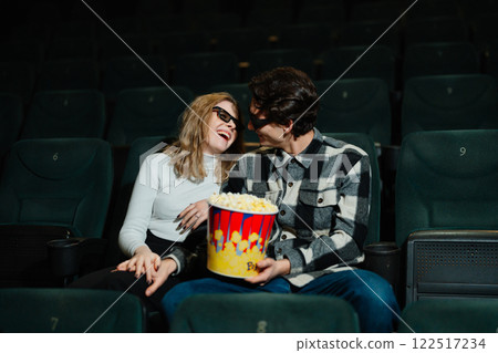 Young couple enjoying a movie night with popcorn in a theater 122517234