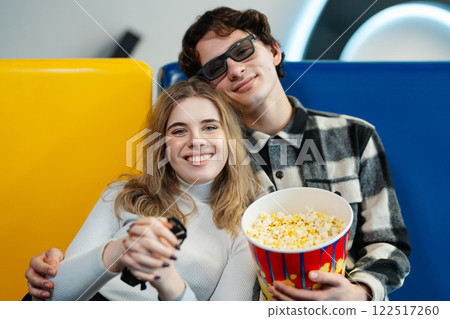 Couple enjoying snacks together while waiting for a movie at the cinema Couple enjoying snacks together while waiting for a movie at the cinema 122517260