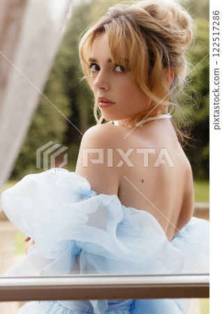Portrait of an elegant woman in a light blue ball gown in a classic interior Portrait of an elegant woman in a light blue ball gown in a classic interior 122517286