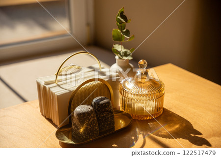 Cutlery, a napkin holder and a vase with a flower on a wooden table 122517479