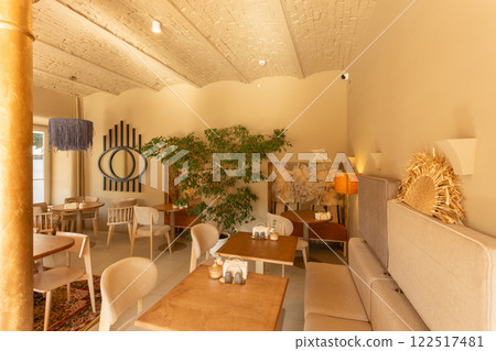 The inviting interior of a coffee shop adorned with warm colors 122517481
