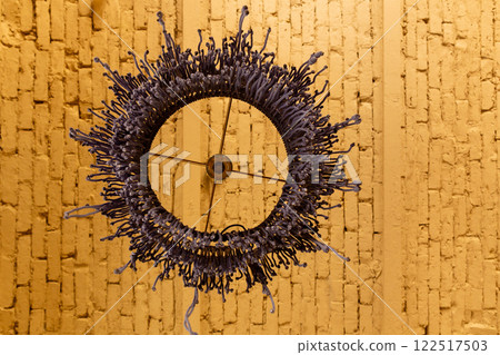 Macrame lampshade with fringes, suspended in front of a warm, background. Macrame lampshade with fringes, suspended in front of a warm, background. 122517503
