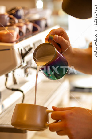 Barista pouring steamed milk to hot coffee to making latte art. Barista pouring steamed milk to hot coffee to making latte art. 122517515