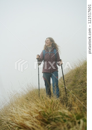 Woman Hiking in Misty Mountains at Foggy Morning Woman Hiking in Misty Mountains at Foggy Morning 122517601