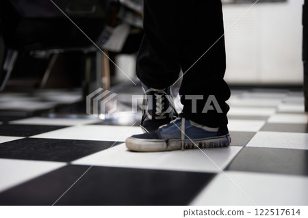 Footwear on black and white checkered floor in a stylish indoor space 122517614