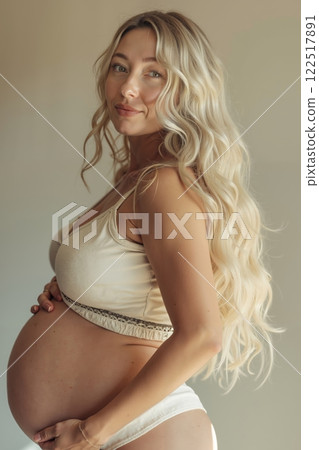 A pregnant woman in a beige bra and white panties 122517891