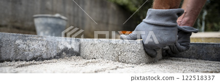 Construction worker paving a sidewalk Construction worker paving a sidewalk 122518337