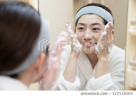 A woman washing her face with foam 122518563