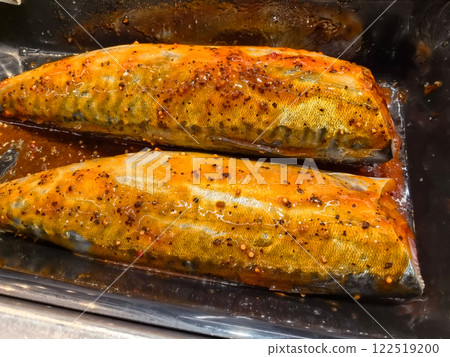 Spiced mackerel fillets glistening with savory marinade for a delicious meal Spiced mackerel fillets glistening with savory marinade for a delicious meal 122519200