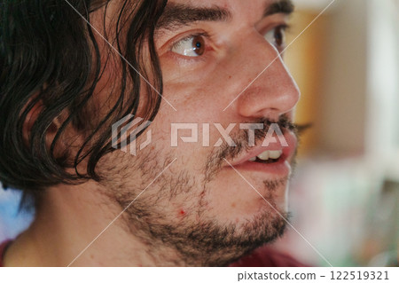 Man displays a look of astonishment, reflecting the excitement of an ongoing local festival filled with bright colors and energy. 122519321