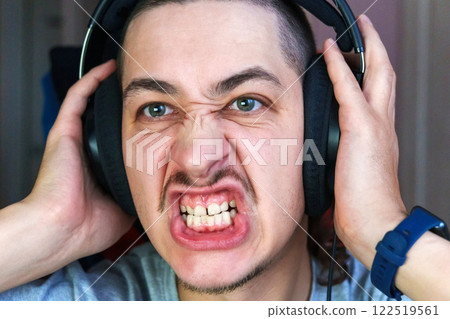 Expression of intense emotion during gaming in a cozy room filled with technology and excitement 122519561