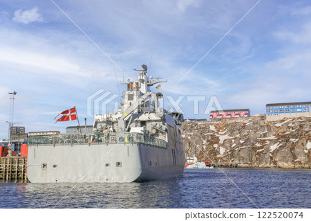 Danish nautical military force guard military ship with Danish flag on the stern waving on the wind, docked at pier in Nuuk city, Greenland 122520074