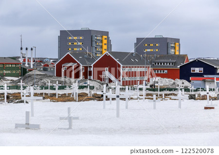 Inuit cemetery with white crosses in Nuuk city center with building in the background, Greenland 122520078