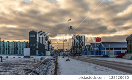 Downtown modern buildings and Aqqusinersuaq the main street of Nuuk city covered in snow in a sunset lights, Greenland 122520080