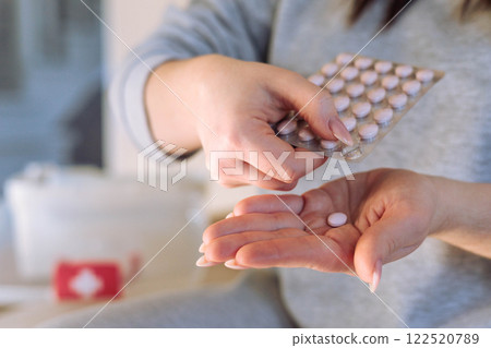 Female hands holding pink round hormonal contraceptive pill. Female hands holding pink round hormonal contraceptive pill. 122520789