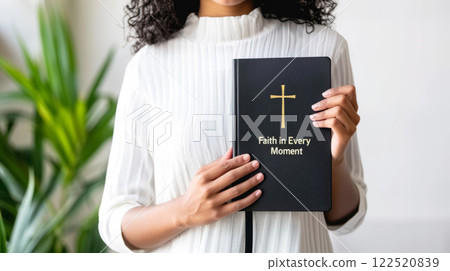 Young Woman Holding a Bible with Cross Cover Young Woman Holding a Bible with Cross Cover 122520839