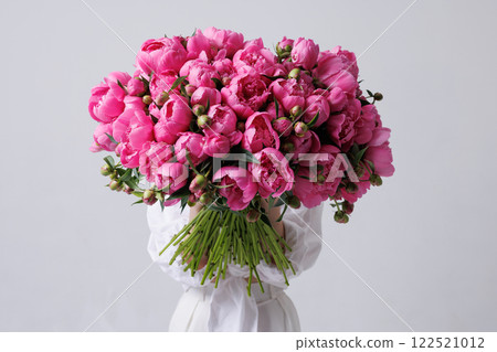girl holding huge bouquet of pink peonies covering her face with them on white background, girl holding huge bouquet of pink peonies covering her face with them on white background, 122521012