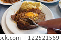 Close-Up of Slicing into a Hearty Meatloaf with Egg, and Mashed Potatoes on a White Plate 122521569