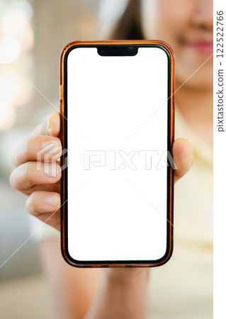 A person holds a smartphone with a blank screen, perfect for mockups or design presentations in a bright indoor environment. A person holds a smartphone with a blank screen, perfect for mockups or design presentations in a bright indoor environment. 122522766