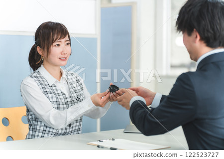 接待處一名女工作人員及一名男顧客交出車鑰匙 接待處一名女工作人員及一名男顧客交出車鑰匙 122523727