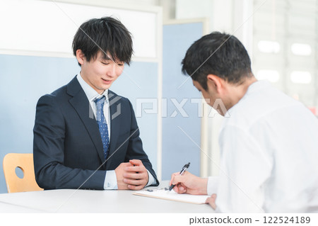 年輕的亞洲商人在接待處為男性顧客服務並讓顧客簽名 122524189