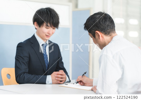 年輕的亞洲商人在接待處為男性顧客服務並讓顧客簽名 122524190