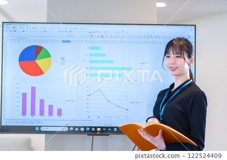 A young businesswoman giving a presentation using a monitor 122524409