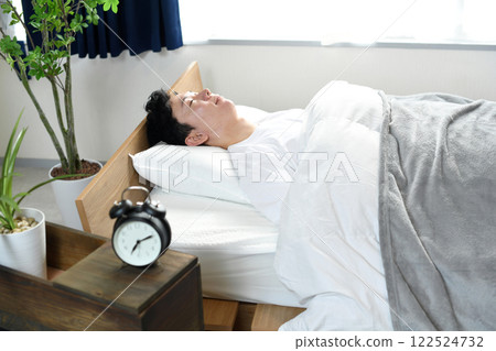 A man having a good night's sleep, deep sleep, and comfortable sleep in his bedroom A man having a good night's sleep, deep sleep, and comfortable sleep in his bedroom 122524732