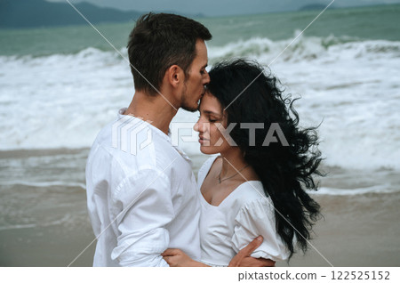 young beautiful couple in love kissing on beach by the sea in summer on vacation close-up 122525152