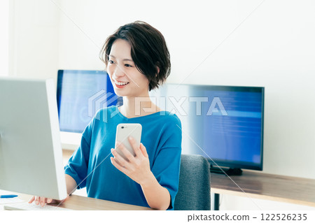 操作一個智能手機的少婦在辦公室 122526235