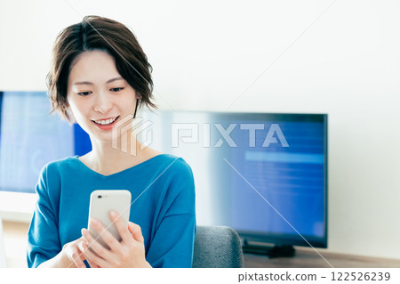 A young woman operating a smartphone in the office 122526239