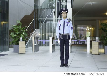 A young security guard standing in the entrance lobby of an office building. Photo courtesy of Sky Perfect Tokyo Media Center. 122526421