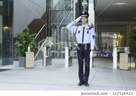 A young security guard standing in the entrance lobby of an office building. Photo courtesy of Sky Perfect Tokyo Media Center. 122526423